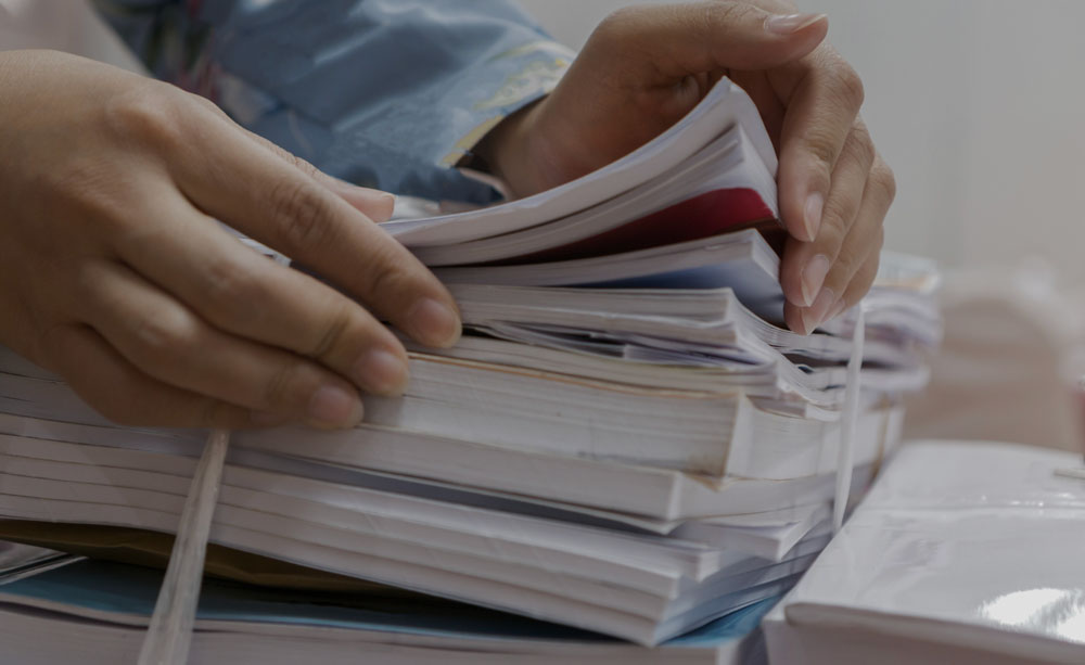 Person fanning pages of a stack of books